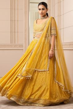 Yellow kalidar sheer brocade lehenga with a pearl-laced waistband and gota border. Paired with a mirror-embroidered round-neck blouse with pearl detailing on the hem along with delicate wings with gota trims and fringe embellished dupatta.
Component: 3
Pattern: Embroidered
Type Of Work: Geometric
Neckline: Round
Sleeve Type: Elbow Sleeves
Fabric: Silk organza brocade
Color: Yellow
Other Details: 
Back tie-up
Embroidered waistband
Tassel detail
Striped panel
Occasion: Destination Wedding - Aza Fa Choli With Sheer Dupatta For Reception Navratri, Eid Sharara With Pallu For Reception, Sets With Dupatta For Reception During Navratri, Transitional Organza Lehenga With Cutdana, Festive Choli With Sheer Dupatta For Reception, Lehenga With Pallu In Organza, Diwali Organza Lehenga With Traditional Drape, Transitional Lehenga With Pallu In Organza, Semi-stitched Organza Lehenga In Traditional Drape