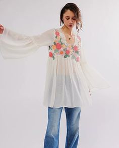 So femme and floral-adorned, this chic tunic is featured in a soft fabrication and billowy silhouette with bold bell-shaped sleeves and subtle ruffled trim. Fit: Billowy, shapeless silhouette; tunic-length styleFeatures: Soft fabrication with a lightweight feel, square neckline, embroidered floral detailing, bell-shaped sleeves, subtle ruffled trim, gathered detail for added dimensionWhy We ❤ It: This billowy top can be layered over your favorite shorts or slouchy pants for effortlessly versatil Spring Blouse With Sheer Flowy Sleeves, Spring Blouse With Sheer Sleeves And Flowy Fit, Bohemian Peasant Top With Elastic Sleeves For Spring, Spring Billowy Blouse With Bishop Sleeves, Billowy Bishop Sleeve Blouse For Spring, Summer Flowy Blouse With Elastic Sleeves, Spring Bohemian Blouse With Elastic Sleeves, Spring Flowy Tops With Elastic Sleeves, Feminine Flowy Peasant Top For Spring