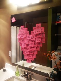 a bathroom sink under a mirror covered in sticky notes