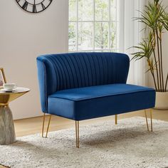 a blue chair sitting on top of a rug in a living room next to a clock