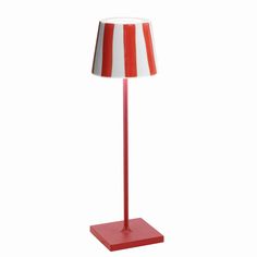 a red and white lamp with a striped shade