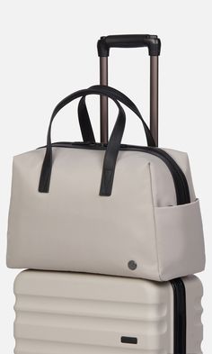 Designed to be the perfect piece of hand luggage, our overnight bag will sit neatly under the seat in front of you on a plane, and has a back sleeve to slot over a suitcase handle. It doubles up as an ideal gym bag and comes with a detachable shoulder strap (you'll find this inside a pocket on arrival). Inside, there are plenty of slip pockets including one for a laptop. This holdall is finished with premium leather details. Durable nylon Water-resistant Fits a laptop up to 13” Dimensions 16.34 Modern Travel Bag With Adjustable Handle, On-the-go Travel Bag Satchel With Adjustable Handle, Travel Bag With Adjustable Double Handle, Travel Weekender Tote With Adjustable Handle, Travel Weekender Bag With Adjustable Handle, Adjustable Handle Tote Weekender Bag For Travel, Travel Laptop Bag With Adjustable Handle In Satchel Shape, Weekender Tote Bag With Adjustable Handle For Travel, Travel Bag With Detachable Handle