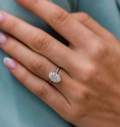 a woman's hand with a diamond ring on it