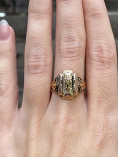 a close up of a person's hand with a gold ring on it,