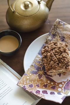 a piece of cake sitting on top of a plate next to a tea pot