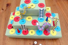 a wooden table topped with a game board and dices on top of each other