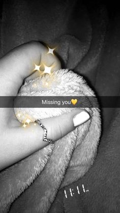 a person's hand holding a teddy bear with the caption missing you on it