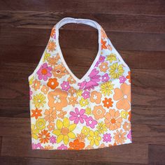 White Cropped Halter Top With Orange, Pink, And Yellow Flowers New Without Tags Size Xs, Fits Like An Xs/Small Length: 15 In White Y2k Halter Neck Tank Top, Cute V-neck Tank Top For Spring, Y2k Printed Tank Top For Spring, Pink V-neck Crop Top For Summer, Y2k Tank Top For Spring Beach Outings, Spring Floral Print V-neck Halter Top, White Y2k Tank Top For Beach, Spring Y2k Halter Neck Top, White Y2k Tank Top For The Beach