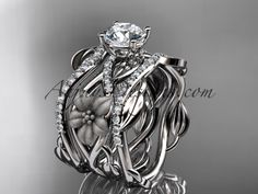 an intricately designed wedding ring with flowers and leaves