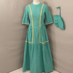 Well Constructed Handmade Dress, Likely For A Reenactment Or Costume. Includes Matching Cap. Condition Very Good, Two Light Spots Found - See Close Up Pics. Washable And Washed. Pretty Aqua Green Calico Floral Print With Yellow Trim And Decorative Buttons. Shown On A 6 Dress Form And Has Some Room, Please Go By Measurements. Length 55", Bust 37", Pit To Pit 18", Waist 28.5". Yellow Trim, Light Spots, Handmade Dress, Dress Handmade, Prairie Dress, Decorative Buttons, Handmade Dresses, Dress Form, Aqua Green