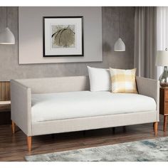 a living room with a white couch and two lamps on either side of the couch