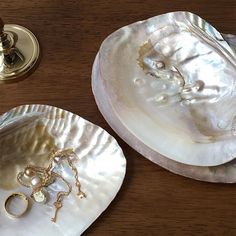 two plates with rings on them sitting on a table next to a candle holder and door knob