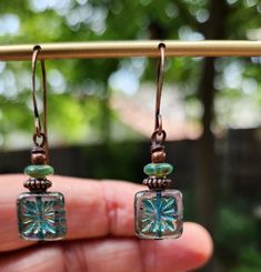 The centerpiece for these stunning boho earrings is a transparent turquoise tile bead with a gorgeous starburst.  Another petite pair of earrings! Simply gorgeous Czech glass! Love the look! These unique beauties are just under two inches in length, including the copper hooks.  The turquoise Czech glass square beads are accented with a stack of copper beads interspersed with Turquoise disc beads.  These square starburst beads are some of my favorite beads because of the richness of the color, their transparency and the design.  One of a kind design. Lightweight! Handmade. Smoke free artist studio. Turquoise Tile, Tile Earrings, Starburst Earrings, Square Bead, Square Earrings, I Love Jewelry, Earrings Boho, Copper Earrings, Jewelry Inspo