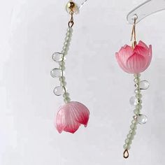 the pink flower is hanging from the hooks on the earring wires with beads