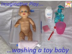 a baby doll sitting in a plastic container next to other items on a bed with the caption imagine play washing a toy baby