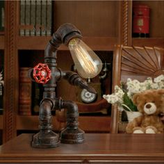 a lamp that is sitting on top of a table next to a teddy bear and bookshelf