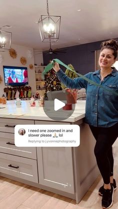 a woman standing in front of a kitchen counter holding up a green object with the words i need one covered in and shower please