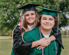 a couple of people that are in the grass with some graduation caps and gowns