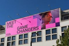 a large billboard on the side of a building advertising game changers, with an image of a woman's face