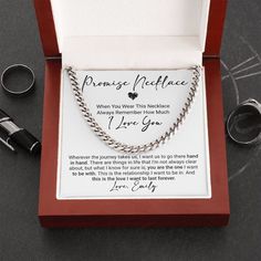 an open box with two rings and a necklace in it on a table next to other items