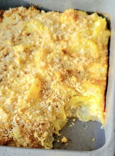 a casserole dish with cheese and bread crumbs on top in a pan