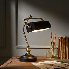 a lamp that is sitting on top of a table next to a book and some books