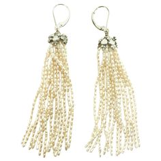 These white rice pearl tassel earrings with 14k white gold lever-backs with a silver rhodium-plated cup are lush and elegant. Flowing out of the roundel are strands of beautiful white rice pearls. At almost 3.5 inches inches, these earrings are timeless and striking, a stable of any jewelry collection, and perfect for almost any formal outfit. The shape of the pearls allows for a beautiful glow in shimmer in the light. Elegant Silver Long Drop Tassel Earrings, Elegant Beaded Tassel Earrings, Elegant Silver Earrings With Tassels, Elegant Formal Tassel Drop Earrings, Elegant Dangle Tassel Jewelry, Elegant Long Drop Tassel Earrings For Formal Occasions, Elegant Long Drop Tassel Jewelry, Elegant Evening Jewelry With Tassels, Elegant Pearl Drop Tassel Earrings