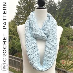 a blue crocheted scarf on top of a white mannequin