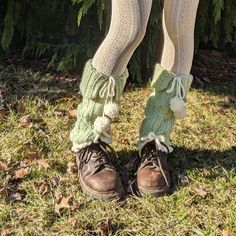 the legs and leg warmers of a woman standing in front of a pine tree