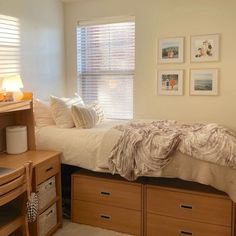 a bedroom with a bed, dressers and pictures hanging on the wall above it