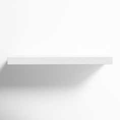 an empty white shelf on the wall