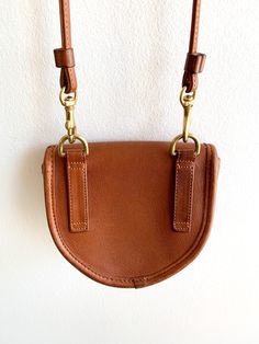 Hands down favorite purse. Vintage Coach at its finest with all the Bonnie Cashin genius brass hardware. Perfect shade of tan leather. Can be converted as a belt bag. Just have to carry you phone separately. Era: 1980'sMade in USA 5.5"(w) x 4.5"(h) x 1.5"(d) Strap drop 24" Condition: Very good. Light wear on brass closure and one small mark on top of flap (see photo). Brown Saddle Bag With Brass Hardware, Everyday Saddle Bag With Brass Hardware, Cognac Saddle Bag With Gold-tone Hardware For Everyday, Everyday Cognac Saddle Bag With Gold-tone Hardware, Cognac Saddle Bag With Removable Pouch, Everyday Crossbody Saddle Bag With Brass Hardware, Vintage Belt Bag With Belt Loops For Everyday Use, Leather Crossbody Saddle Bag With Belt Loops, Leather Belt Bag With Gold-tone Hardware For On-the-go