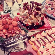 several trays filled with different types of pastries and desserts on top of a table