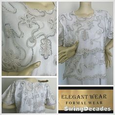 This beautiful white top with silver beading and sequins by Elegant Wear is elegant in a plus size, appropriately 2X. It has never been worn, new with tags.  It is comfortable with a zipper back and three quarter length sleeves, clean and can be hand washed, air dried.  Approximate Measurements: Bust 50" Waist 48" Hips 54" Length 25.5" Sleeve length 13" Labeled 2X, measures, like between current 2X and 3X. Please measure carefully for a perfect fit.  This has never been worn and still has the or Formal Embellished White Tops, White Embellished Tops For Formal Occasions, Elegant Beaded Tops For Wedding, White Embellished Tops For Wedding, White Beaded Top For Party, Fitted White Top For Holidays, White Embellished Wedding Tops, White Pearl Embroidery Top For Party, White Beaded Party Top