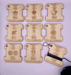 six wooden tags with names and symbols on them, all engraved in wood or metal