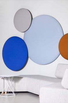 a white couch sitting next to a wall with three circles on it