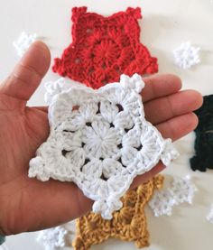 someone is holding three crocheted squares in their hands