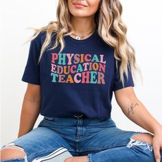 a woman sitting on the ground wearing a t - shirt that says physical education teacher