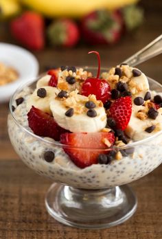 a bowl filled with bananas, strawberries and chia pudding on top of a wooden table