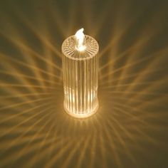 a candle that is lit up in the middle of a room with light streaming through it