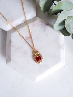 "The Sacred Heart is used to symbolize the divine love of Jesus, healing & gratitude. Our Sacred heart necklace features a dainty gold filled red and gold mexican milagro heart charm set on an 18k gold filled chain dainty and perfect for everyday. Give as a gift for Mother's Day, Birthday, Valentines Day or any Religious ceremony.  LINK TO MATCHING SACRED HEART EARRINGS: https://www.etsy.com/listing/1643055230/sacred-heart-earrings-red-flaming-heart - 18K gold filled milagro heart pendant - 18K gold filled 18\" satellite chain CARE: GOLD FILLED JEWELRY In order to prolong the life of your jewelry avoid exposing them to lotions, perfumes, or harsh chemicals. Do not exercise, swim, or shower with your jewelry. Each piece comes packaged in a sturdy sealed plastic bag that can be used to store Gold Catholic Jewelry, Red Jewelry For Valentine's Day Gift, Heart Beads Necklaces For Valentine's Day Keepsake, Valentine's Day Heart Beads Necklace Keepsake, Valentine's Day Heart Beaded Necklace Keepsake, Valentine's Day Keepsake Necklace With Heart Beads, Spiritual Necklace For Valentine's Day Gift, Red Pendant Necklace For Keepsake, Spiritual Necklace For Valentine's Day Gift For Her