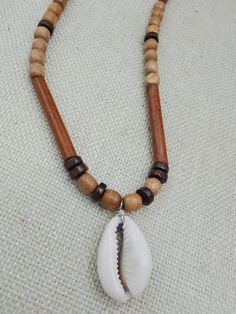 The necklace is a 2 inch Cowrie necklace. it is beaded with wooden and carved beads. Thr necklace is approximately 22 inches long. it closes with a clasp. if you have any questions please feel free to contact us at anytime. Cowrie Necklace, Cowrie Shell Necklace, Necklace Beaded, Shell Necklace, Cowrie Shell, Unisex Jewelry, Shell Pendant, Shell Necklaces, Pendant Necklaces