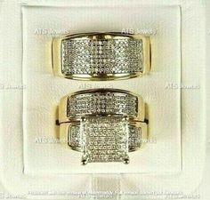 two yellow gold rings with diamonds in the middle on a white leather case for display