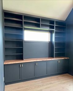 an empty room with built in bookshelves and cabinets