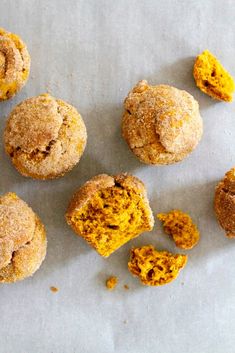 several muffins with powdered sugar on top are arranged in a circle and scattered around