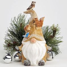 a figurine with an owl sitting on top of it's head, surrounded by other ornaments