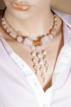 A beautiful necklace made with a lot of care and creativity from rose quartz, white crackled quartz, cat's eye and white agate beads. This unique piece is made of round and cuboid gemstones, with 2 uncut raw rose quartz gemstones in the center. For the glamorous appearance, the 3 strands of pearls are integrated in the center of the necklace and a deep neckline adorned with the piece of jewelry. All intermediate elements and lobster clasp in the back are gold plated with genuine 18K gold. The le White Rose Quartz Round Bead Necklaces, White Rose Quartz Round Bead Necklace, White Rose Quartz Jewelry For Jewelry Making, White Rose Quartz Necklaces With Gemstone Beads, White Rose Quartz Necklaces With Natural Stones, White Rose Quartz Necklace With Natural Stones, Handmade Elegant Rose Quartz Beaded Necklaces, Rose Quartz Faceted Beads Necklace Gift, Gift Rose Quartz Necklace With Faceted Beads