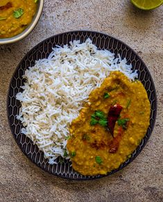 a black plate topped with rice and curry