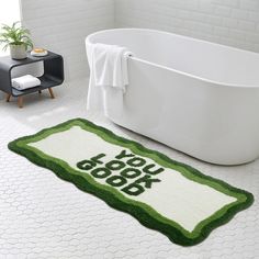 a bath tub sitting next to a rug with the words you look good on it