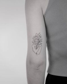 a woman's arm with a flower tattoo on the left side of her arm